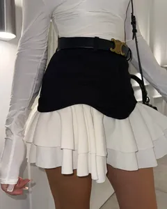 Detalle de una elegante minifalda evasé con volantes en contraste blanco y negro.