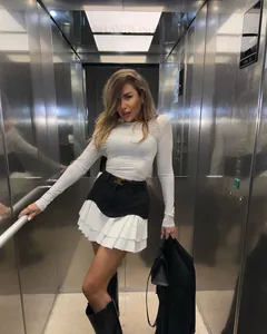 Minifalda evasé chic en blanco y negro lucida por modelo en un ascensor