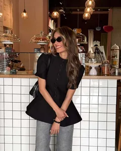 Elegante top peplo nero con maniche a sbuffo e abbottonatura singola per l'estate