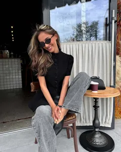 Dettaglio di una camicia nera a maniche corte da donna con colletto alla coreana elegante.