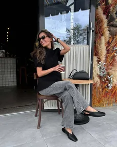 Elegante camicia nera a maniche corte con colletto alla coreana in un caffè
