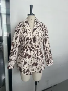 Détail d'un blazer à imprimé vache avec taille cintrée et ceinture boutonnée