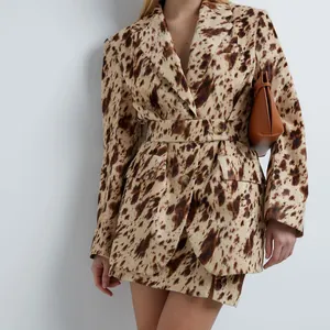 Gros plan sur un blazer imprimé animal marron avec taille cintrée et jupe assortie.
