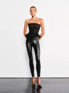 Détail d'un haut corset à basque noir brillant avec un legging en similicuir élégant