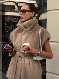 Détail d'un gilet élégant en fausse fourrure beige avec col montant et ceinture à nouer