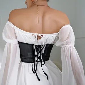 Vista posteriore dell'elegante corsetto in rete nera con lacci sopra un abito bianco