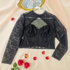 Dettaglio del sexy top nero in pizzo e mesh con maniche lunghe, cut-out e ferretto.