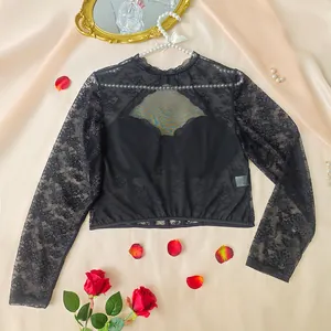 Dettaglio top in pizzo nero con catena di perle e inserti in rete trasparente
