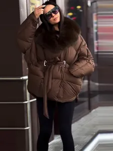 Detailed view of women's brown thick puffer jacket with large fur collar and waist tie