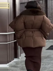 Stylish back view of a brown puffer jacket with faux fur collar and waist belt.