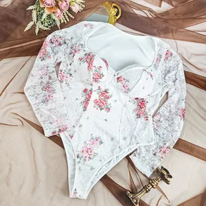 Close-up detail of white floral lace long sleeve bodysuit featuring sheer mesh design