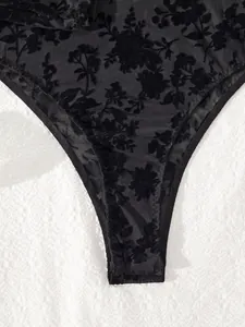 Close-up of black floral flocked mesh bodysuit with intricate detail