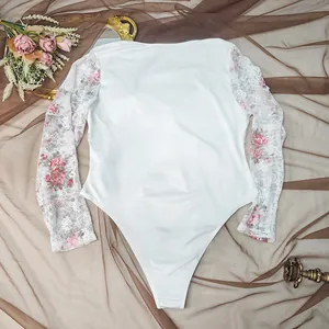 Detailed view of a white plus size long sleeve bodysuit with floral lace sleeves.