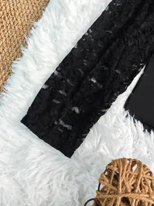 Vue macro détaillée de la manche en dentelle florale noire d'un body amincissant