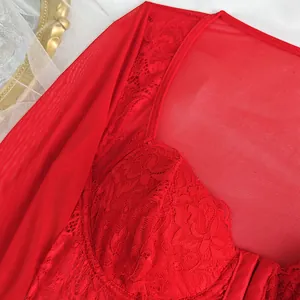 Primer plano de un top corsé rojo de malla y encaje con bordado floral detallado.