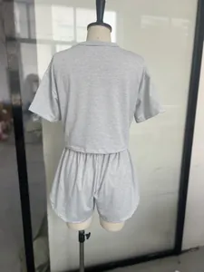 Détail d'un ensemble de détente en maille rayée gris et blanc présenté sur un mannequin.