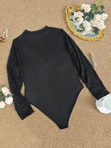 Detailaufnahme eines eleganten schwarzen Bodysuits mit floralen Spitzenärmeln und Stehkragen