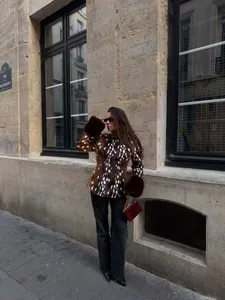 Lifestyle-Aufnahme einer Frau mit Vintage-Kunstpelzjacke mit Rehkitz-Print in der Stadt