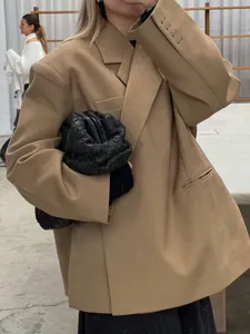 Detail view of an oversized camel blazer with a unique diagonal placket and V-neckline.