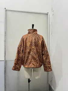 Achteraanzicht van een trendy bruin kort jasje met stippen op een etalagepop in studio