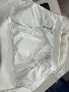 Detaillierte Nahaufnahme des weißen Satinfutters und Rippsaums einer Winterjacke