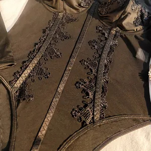 Detailed view of black lace patchwork and mesh panels on a fishbone bodysuit