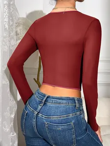 Rückansicht eines eng anliegenden weinroten Langarm-Crop-Tops aus Mesh mit Blue Jeans