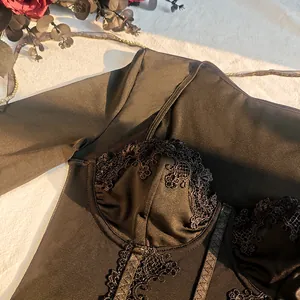 Close-up showing the intricate lace patchwork and mesh texture of this black corset bodysuit.