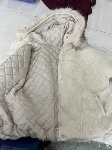 Dettaglio della fodera trapuntata e del bordo in pelliccia sintetica sul cappotto