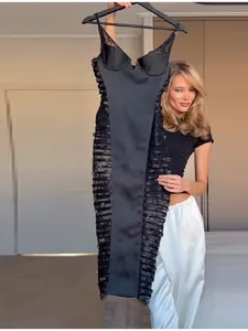 Close-up of a sexy black midi dress with sheer lace side panels and strap details