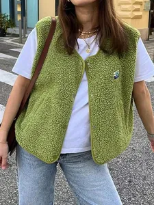 Gilet sans manches en polaire verte sur t-shirt blanc et jean bleu style rue