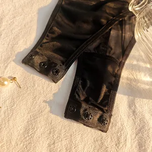 Close-up detail showing the snap button crotch closure on a black lace mesh bodysuit