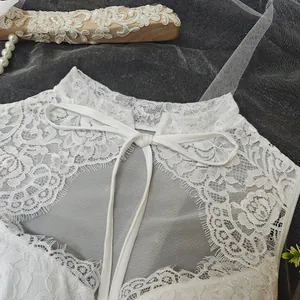 Close-up of white lace corset top with delicate tie-front detail and mesh
