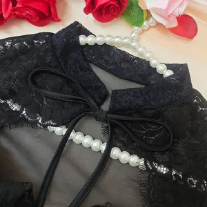 Detail of black floral lace top featuring a delicate mesh collar and elegant bow