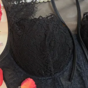 Close-up detail showing the intricate floral lace pattern on a black underwire corset top