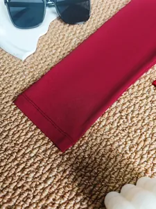 High-quality close-up of burgundy bodysuit long sleeve cuff with neat double-stitch seams.