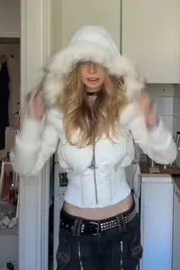Detailaufnahme einer stylischen weißen kurzen Steppjacke mit Kunstpelzbesatz an der Kapuze