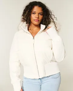Detailansicht einer modischen weißen Damen-Pufferjacke mit kurzer Passform und Kunstfellkapuze.