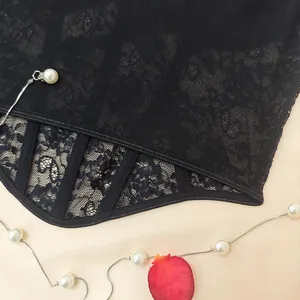 Detailed view of the intricate black floral lace and mesh fabric of the boned camisole.