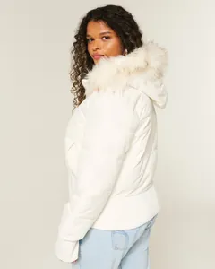 Seitenansicht einer weißen Damen-Steppjacke mit Kapuze und weichem Kunstfellkragen
