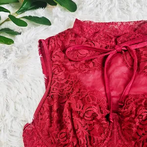 Detailed close-up of red floral lace corset top with elegant ribbon bow tie
