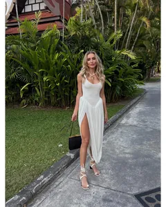 Elegant white sleeveless maxi dress featuring a high leg slit and pleated skirt for summer resort