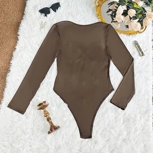 Detailed view of an elegant brown long-sleeved bodysuit laid on a white furry rug