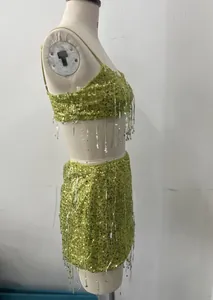 Side view of green sequined crop top and skirt set with tassels on mannequin