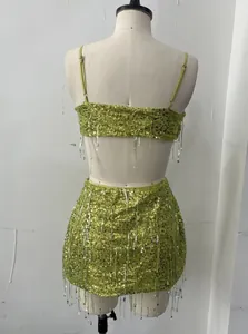 Detailed back view of lime green sequin two-piece set with silver tassels on mannequin