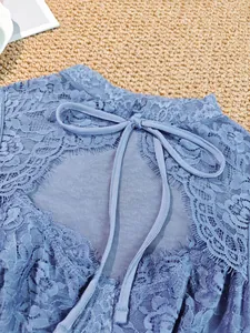Close-up of elegant blue lace top with delicate eyelash trim and tie-back detail