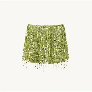 Detailed view of lime green sequin mini skirt featuring shimmering tassel fringe accents
