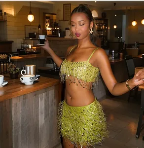 Detail view of the lime green sequin fringe top and mini skirt set in a cafe setting