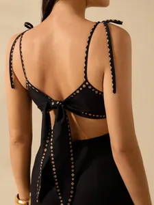 Detailed view of elegant black backless dress featuring back bow tie and chic embroidery