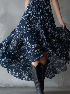 Detail shot of a navy blue bohemian floral print maxi dress with a wide flowing skirt.